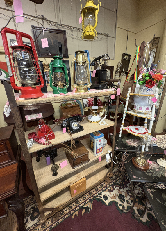 Vintage lanterns, rotary phones, and antique collectibles on display. Perfect for farmhouse décor, rustic styling, and retro collectors looking for unique home accents.